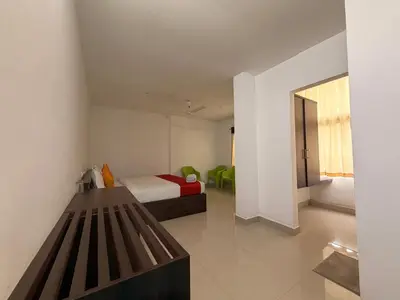 a bedroom with a bed and a bench in a room at Moon Way in Neriyamangalam