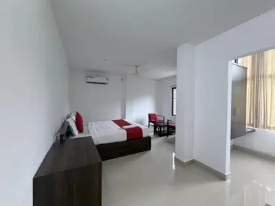 a bedroom with a bed and a table in it at Moon Way in Neriyamangalam