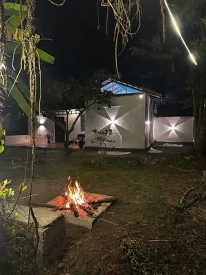 a fire pit in a yard at night at Sky Holiday Homestay Cottages Madikeri Kushalnagar Coorg in Kushālnagar