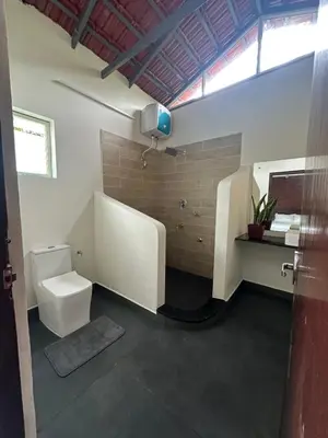 a bathroom with a toilet and a sink at Sky Holiday Homestay Cottages Madikeri Kushalnagar Coorg in Kushālnagar