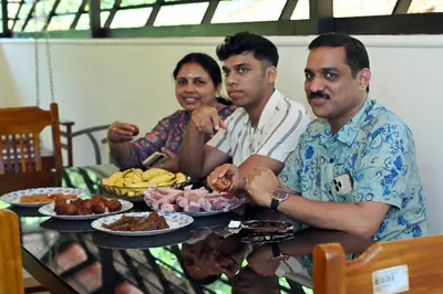 a group of people sitting at a table with food at vintage inn in Kommeri