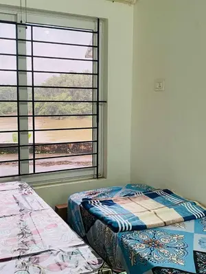 a bedroom with two beds and a large window at Verito Home Stay