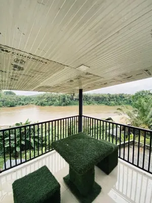 a balcony with a table and a view of a river at Verito Home Stay