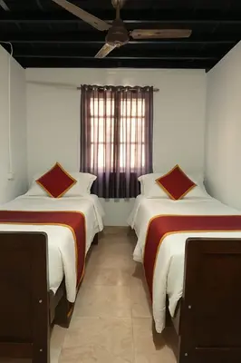 a bedroom with two beds and a ceiling fan at The Coffee Cube in Kaniyāmbetta