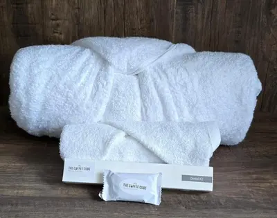 a pile of white towels sitting on a wooden floor at The Coffee Cube in Kaniyāmbetta