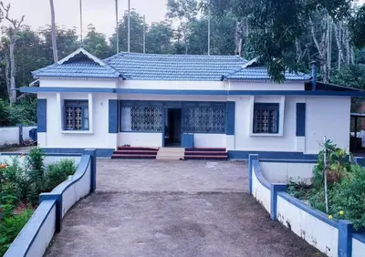 a small white house with a blue roof at The Coffee Cube in Kaniyāmbetta