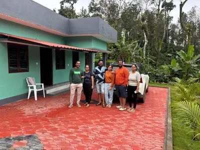 a group of people standing in front of a house at Misty huts home stay in Madikeri