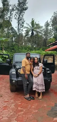 a man and a woman standing in front of a truck at Misty huts home stay in Madikeri