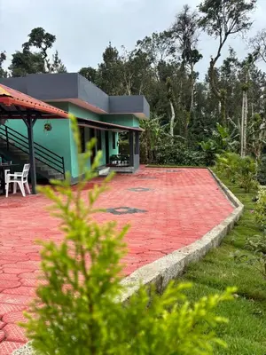 a house with a red brick patio in front of it at Misty huts home stay in Madikeri