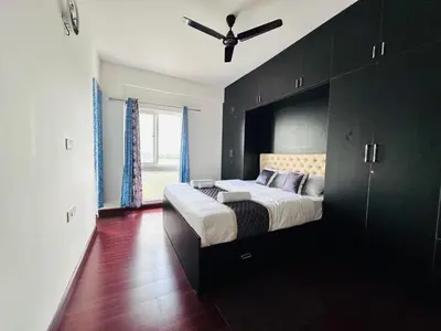 a bedroom with a bed with a ceiling fan at Pearl Home Luxury 3Bhk family-friendly Appartment in Mysore