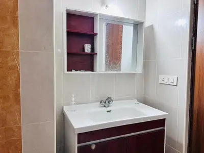 a bathroom with a sink and a mirror at Pearl Home Luxury 3Bhk family-friendly Appartment in Mysore