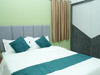a bedroom with a large bed with blue pillows at Serene Legacy in Mysore