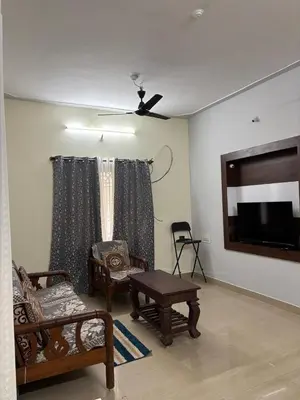 a living room with furniture and a flat screen tv at Sihi-2 bhk Non AC and Penthouse AC Rooms in Mysore