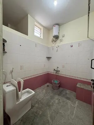 a bathroom with a toilet and a sink in it at Sihi-2 bhk Non AC and Penthouse AC Rooms in Mysore