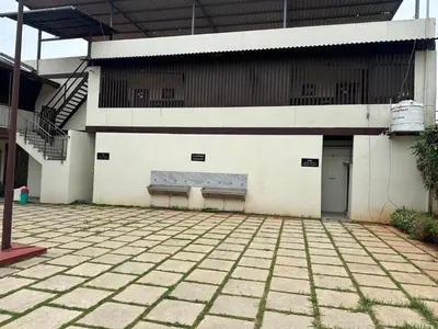 a building with a bench on the side of it at Athithi Comforts in Mysore