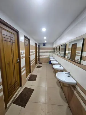 a bathroom with a row of sinks and mirrors at Lowfare Dormitory in Kozhikode