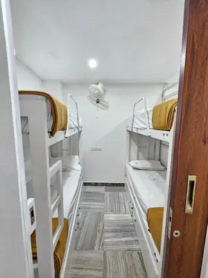 a small room with two bunk beds in it at Lowfare Dormitory in Kozhikode