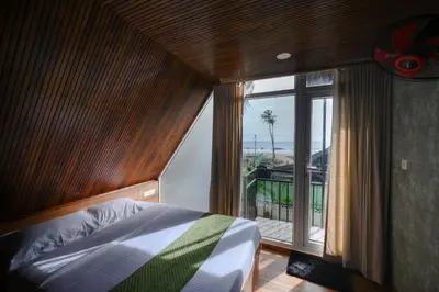 a bedroom with a bed and a large window at Vadanapilly Beach Villa for 8-10 adults in Irimbranallūr