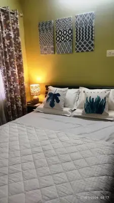 a bedroom with a large bed with white sheets and pillows at Private 1BHK Kerala Village Homestay with Open Veranda near Thrissur in Cheruthuruthi