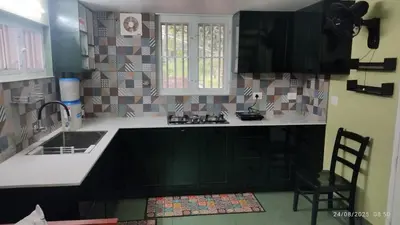 a kitchen with a sink and a counter top at Private 1BHK Kerala Village Homestay with Open Veranda near Thrissur in Cheruthuruthi