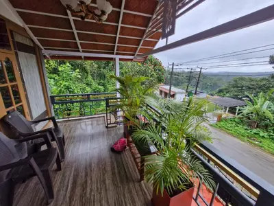 a balcony with plants and a view of a street at Coorg Coffee Tales in Suntikoppa