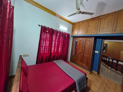 a bedroom with a red bed and red curtains at Coorg Coffee Tales in Suntikoppa
