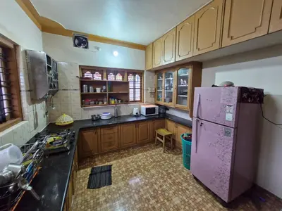 a kitchen with a purple refrigerator and wooden cabinets at Coorg Coffee Tales in Suntikoppa