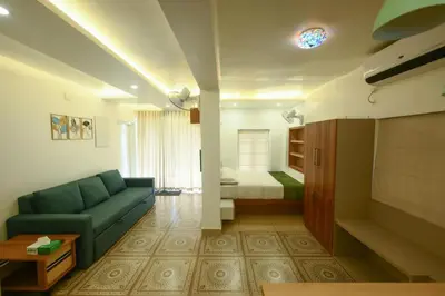 a living room with a couch and a bed at Heaven-Vadanapilly Beach Villa in Irimbranallūr