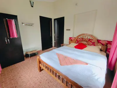 a bedroom with a large bed with a wooden headboard at 7th Heaven Kannur in Kannur