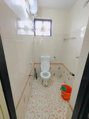 a small bathroom with a toilet and a window at 7th Heaven Kannur in Kannur