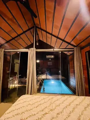 a bedroom with a swimming pool in a house at Misty Slope in Panamaram