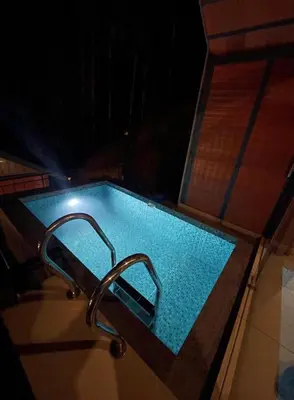 a swimming pool with a faucet in a house at Misty Slope in Panamaram