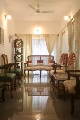 a living room with a couch and tables and a window at Fairwinds Coorg - Boutique Homestay at Coffee Farm in Virajpet