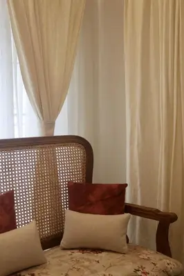 a bedroom with a bed with pillows and a window at Fairwinds Coorg - Boutique Homestay at Coffee Farm in Virajpet
