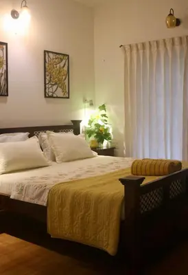 a bedroom with a large bed and a window at Fairwinds Coorg - Boutique Homestay at Coffee Farm in Virajpet