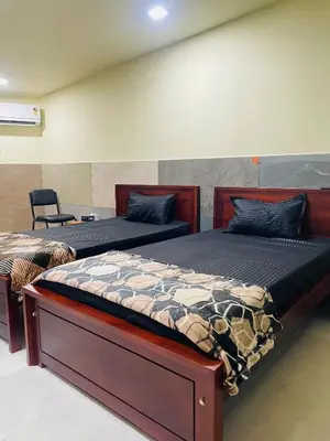 a bedroom with two beds and a chair at Mp DREAMS ROOMS in Edappāl