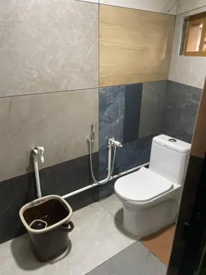 a bathroom with a toilet and a trash can at Mp DREAMS ROOMS in Edappāl