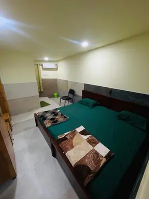 a bedroom with a green bed in a room at Mp DREAMS ROOMS in Edappāl