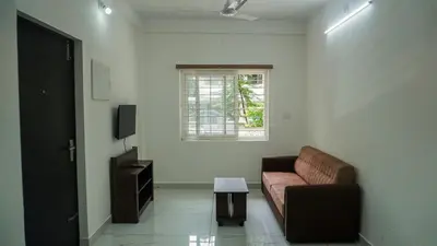 a living room with a couch and a window at Panakkal Homes in Guruvāyūr