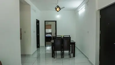 a dining room with a table and chairs at Panakkal Homes in Guruvāyūr