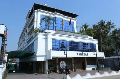 a white building with a flag on top of it at The Surya, Cochin in Angamali