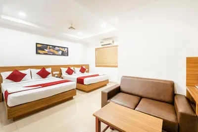 a hotel room with two beds and a couch at Hotel faaz international in Thottada