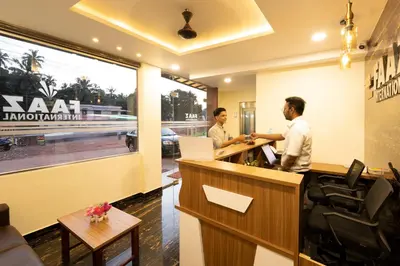two men standing at a reception desk in a office at Hotel faaz international in Thottada