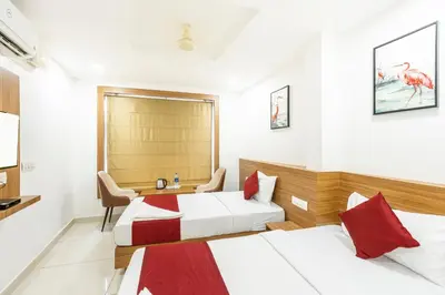 a hotel room with two beds and a desk at Hotel faaz international in Thottada