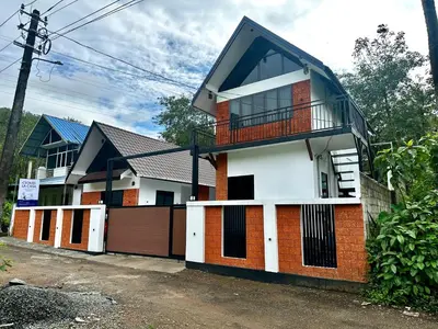a red and white house with a balcony at Cloud Lacasa in Athirappilly