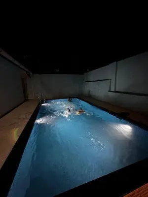 two people swimming in a large swimming pool at Cloud Lacasa in Athirappilly