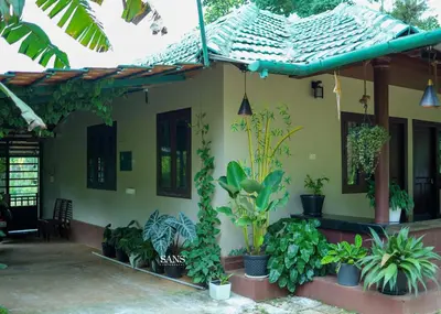 a house with plants in front of it at Paddy Land in Wayanad