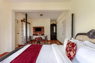 a bedroom with a large bed and a table at Mihirika's Nirvana 5-BHK With Garden, Gazebo, Bonfire Pit & Scenic Views in Ooty