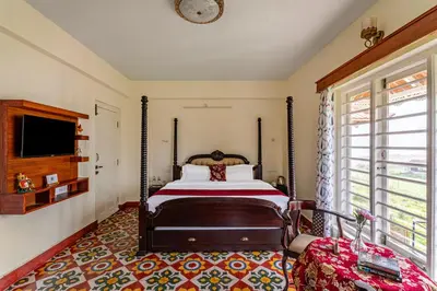 a bedroom with a bed and a large window at Mihirika's Nirvana 5-BHK With Garden, Gazebo, Bonfire Pit & Scenic Views in Ooty