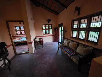 a living room with a couch and a bed at Namma Hatti, Traditional Home in Chattanahalli